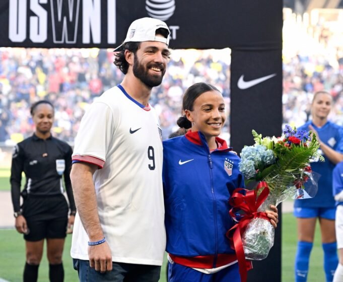 Dansby Swanson dan istrinya, Mallory Swanson, berdiri bersama di lapangan sepak bola, Mallory merasa terhormat untuk pertandingan ke -100nya