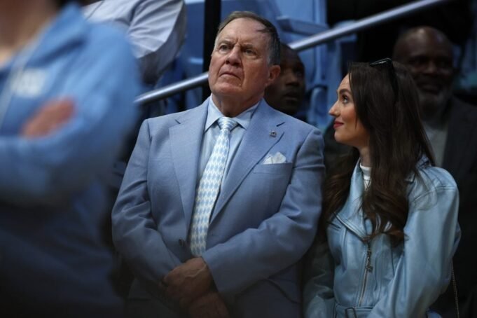 Pelatih kepala sepak bola North Carolina Tar Heels Bill Belichick dan pacarnya Jordon Hudson melihat selama paruh pertama pertandingan antara North Carolina Tar Heels dan Duke Blue Devils di Dean E. Smith Center pada 08 Maret 2025 di Chapel Hill, North Carolina.