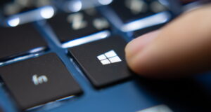 Ujung jari menekan tombol keyboard dengan logo windows di atasnya