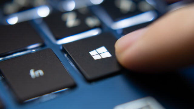 Ujung jari menekan tombol keyboard dengan logo windows di atasnya
