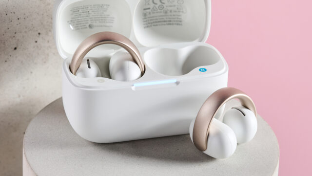 Satu kuncup di dalam pengisian Aeroclip Soundcore Anker dan satu diposisikan di depan kasing pengisian.