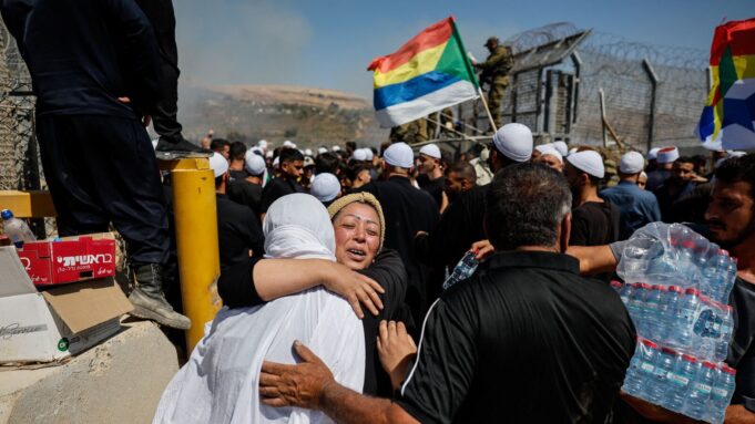 A Druze woman from Syria, meets her sister as she crosses to the Israeli side from the open border to check her family members, amid the ongoing conflict in the Druze areas in Syria, near the ceasefire line between the Israeli-occupied Golan Heights and Syria, July 16, 2025. REUTERS/Ammar Awad