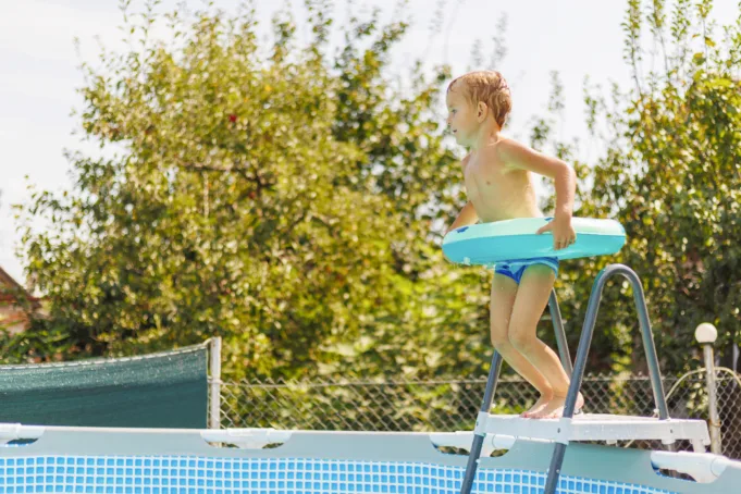 child jumping in above-ground pool