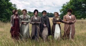 The Bennet women walk in a line through a field with their arms linked