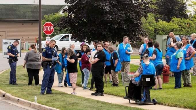 Michigan State Police officers talk to employees near the scene after a stabbing incident at a Walmart in Traverse City, Mich., Saturday July 26, 2025. (Jan-Michael Stump/Traverse City Record-Eagle via AP)