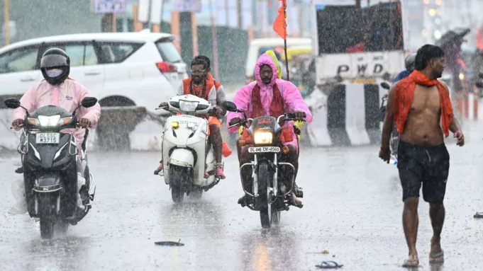 Commuters are seen during sudden rains at Shastri Park in New Delhi, India, on Tuesday, July 22, 2025.  (Photo by Sanchit Khanna/ Hindustan Times)