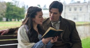 Cora reads to Liam on a bench outside a castle
