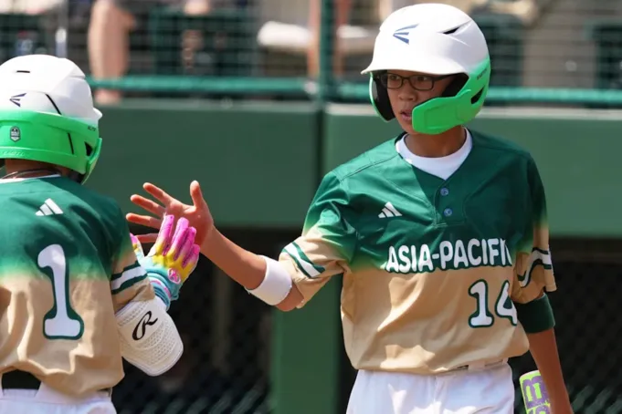Taiwan's Chen Shi-Hong (14) celebrates with Chen Yi-Reng (1) after scoring on a hit by Muhammad Zaman off Aruba's Jayderick Wederfoor (18) during the third inning of the International Championship baseball game at the Little League World Series tournament in South Williamsport, Pa., Saturday, Aug. 23, 2025. (AP Photo/Gene J. Puskar)