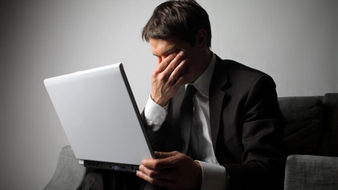 Tired person looking at their laptop