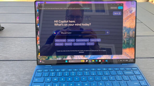 Lenovo Yoga Slim 9i duduk di atas meja piknik di luar