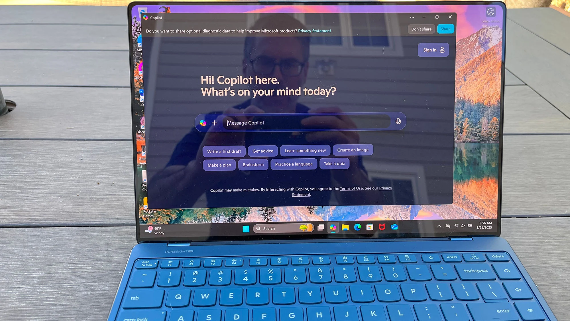 Lenovo Yoga Slim 9i duduk di atas meja piknik di luar