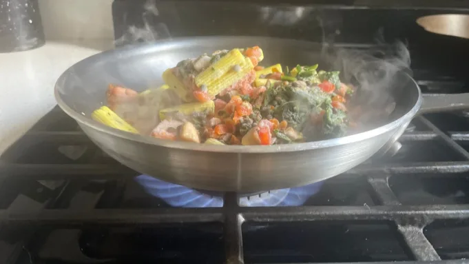 Pan dengan hidangan pasta di atas kompor