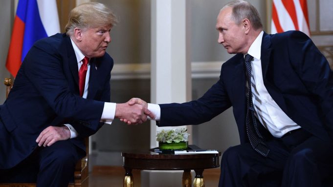 Russian President Vladimir Putin (R) and US President Donald Trump shake hands before a meeting in Helsinki, on July 16, 2018. 